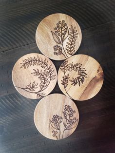 four wooden coasters with floral designs on them