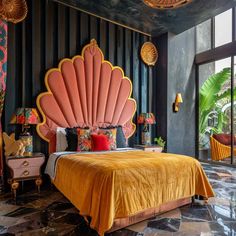 a bedroom with an orange bed and large pink shell headboard