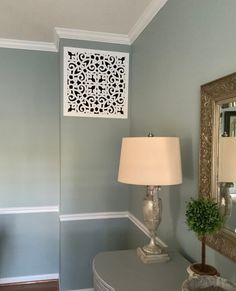 a lamp and mirror in a room with blue walls