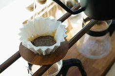 an espresso machine is filled with coffee beans and ground flakes on a wooden table