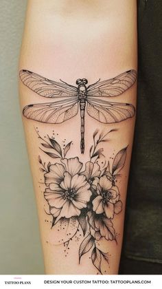 a woman's leg with a dragonfly on it and flowers in the foreground