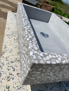 a concrete bench with an artistic design on it's side and the seat is made out of stone