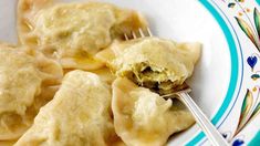 a white plate topped with dumplings and a fork