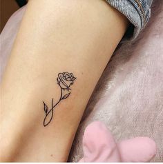 a small rose tattoo on the left side of the leg, with one flower in it's center