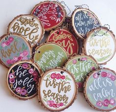 a bunch of wood slices that are decorated with different designs and words on them, all in the same color