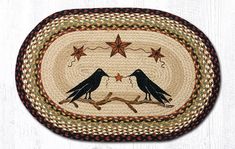 two black birds sitting on top of a wooden floor next to a star shaped rug