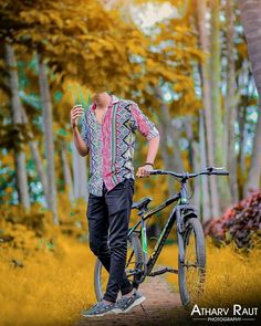 a man standing next to his bike in the woods