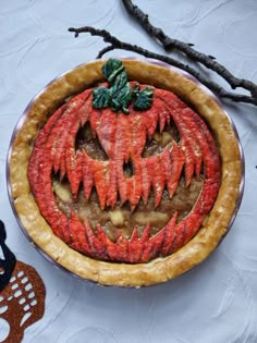 a pumpkin pie is decorated with leaves and other things to make it look like halloween