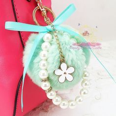 a keychain with a flower and pearls hanging from it's front pocket