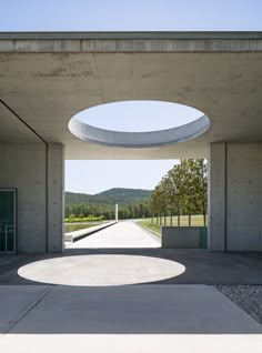 the entrance to an empty building with a skylight on it's roof and trees in the background