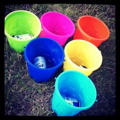 six plastic buckets sitting on the ground with one empty bottle in it's center