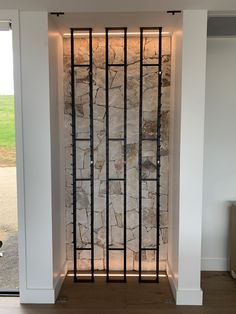 an empty room with a stone wall and metal bars on the front door to it