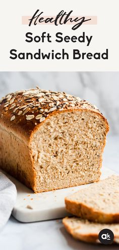 a loaf of soft seedy sandwich bread sitting on top of a white cutting board