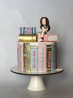 a cake decorated with books and a figurine on top