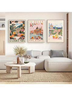 a living room filled with white furniture and paintings on the wall above it's coffee table