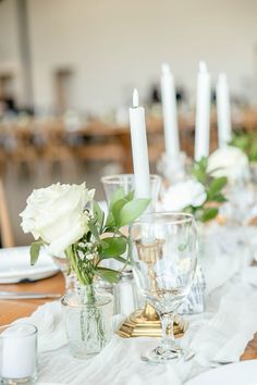 the table is set with white flowers and candles