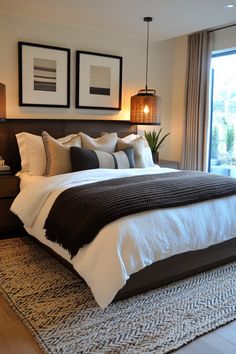 a large bed sitting in a bedroom next to two framed pictures on the wall above it