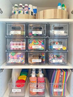 an organized pantry with plastic bins filled with craft supplies