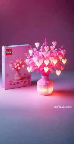 a pink vase filled with lots of hearts next to a boxed box on a table