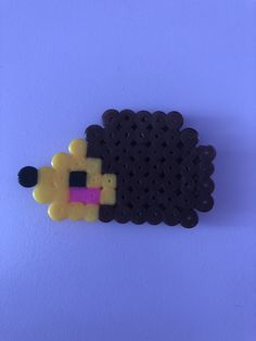 a black and yellow sheep made out of legos on a blue surface with white background