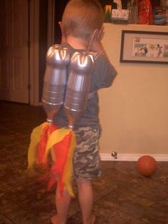 a young boy holding two large metal containers