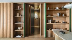 a room with wooden shelves filled with vases and other items