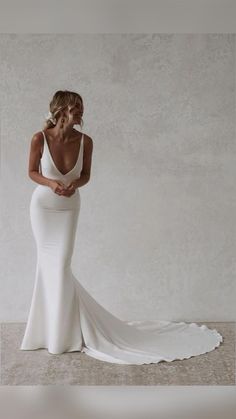 a woman in a white wedding dress posing for the camera