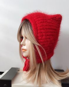 a mannequin's head wearing a red hat with long blonde hair on display