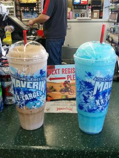 two drinks sitting on top of a counter next to each other in front of a man