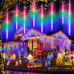 christmas lights on houses and trees in front of a house with santa's sleigh