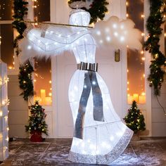 a lighted christmas display in front of a door with lights and wreaths on it