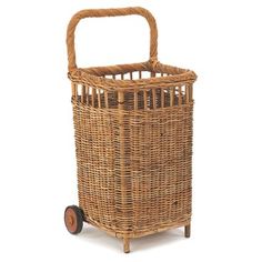 a wicker shopping basket with wheels on the front and side, sitting against a white background