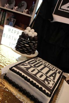 there is a cake on the table with happy birthday written in black and white letters