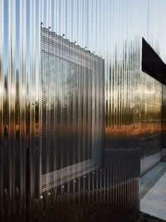 a building that is made out of metal bars with the sun shining on it's side