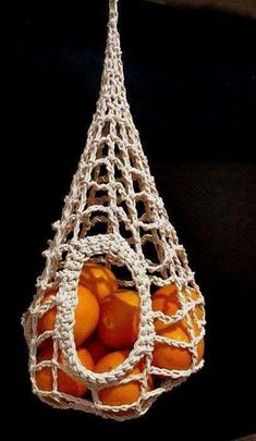 oranges in a bag hanging from a hook