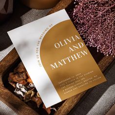 an open book sitting on top of a wooden tray next to dried flowers and candles