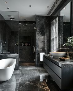 a black and white bathroom with a large bathtub next to a walk in shower