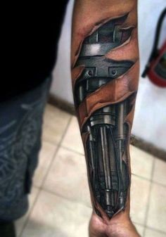 a man's arm with a black and grey tattoo design on his forearm, which has an image of a motorbike coming out of the engine