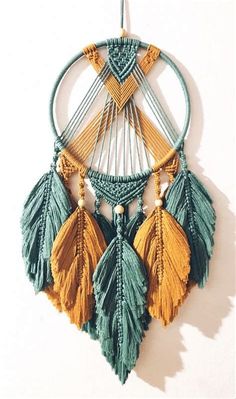 a wall hanging with some tassels attached to it's sides and an arrow on the other side