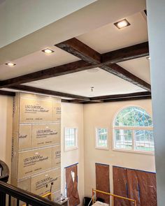 the inside of a house being remodeled with wood beams and insulation tape on the walls