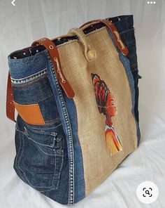 a handbag made out of old jeans with a butterfly painted on the front pocket