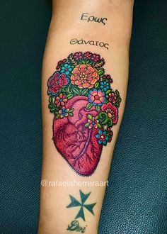 a woman's leg with tattoos on it and flowers in the heart tattoo design