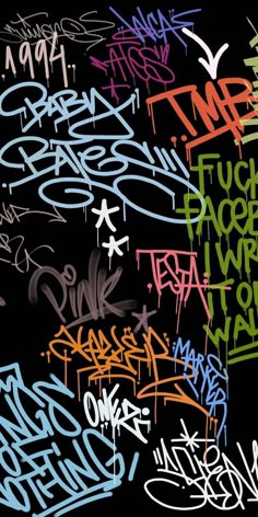 a bunch of graffiti written on the side of a black wall in different colors and sizes