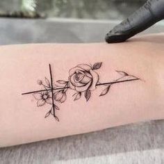 a woman's arm with a rose and arrow tattoo on the left inner forearm