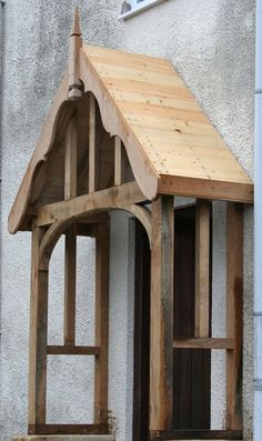 a small wooden structure sitting on the side of a white building next to a window