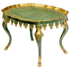 an ornately decorated table with gold trimmings and green paint on the top