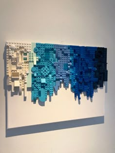 a piece of art made out of legos on a wall next to a white wall