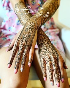 a woman's hands with henna tattoos on her arm and arms, both covered in intricate designs