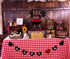 an outdoor bbq party with red and white gingham table cloths, sunflowers, hot dog buns, barbecue grill