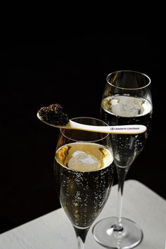 two wine glasses filled with liquid on top of a table